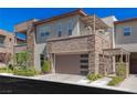 A modern townhome featuring stone accents, a balcony and a covered outdoor space near the two-car garage at 11280 Granite Ridge Dr # 1009, Las Vegas, NV 89135