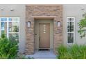 Front door featuring a sidelight and stone pillars with an 'Oh hello' welcome mat at 11280 Granite Ridge Dr # 1009, Las Vegas, NV 89135