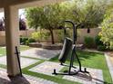 Inviting backyard featuring artificial grass, a paved patio, raised planters, and mature landscaping at 147 Augusta Course Ave, Las Vegas, NV 89148