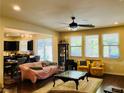 Bright living room featuring hardwood floors, a ceiling fan, and large windows at 147 Augusta Course Ave, Las Vegas, NV 89148