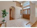 Inviting foyer boasts tile flooring, high ceilings, arched doorway, and decorative front door with transom window at 175 Palta Ct, Henderson, NV 89074