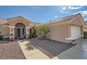 Well maintained desert landscape with tiled roof, pathway to a decorative secure front door and two-car garage at 2401 Ocean Edge Ct, Las Vegas, NV 89134