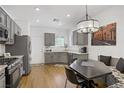 Modern eat-in kitchen with gray cabinets, granite countertops, stainless steel appliances, and stylish light fixture at 2616 Red Planet St, Henderson, NV 89044