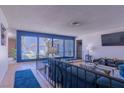 Comfortable living room featuring large windows with natural light, a railing, and view of the outdoor living space at 3030 Liberty Cir, Las Vegas, NV 89121