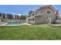Expansive backyard featuring a private in-ground pool, lush green grass, and well-manicured landscaping at 3421 Rochelle Ct, Las Vegas, NV 89121