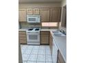 Bright kitchen features white appliances, light cabinets, white countertops and tile flooring at 495 Edgefield Ridge Pl, Henderson, NV 89012