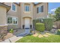 Welcoming front entrance with a white door, stone walkway, and verdant landscaping at 6103 Sundown Crest St, Las Vegas, NV 89113