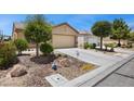 Beautiful single-story home with desert landscaping and a spacious driveway leading to a two-car garage at 7817 Homing Pigeon St, North Las Vegas, NV 89084