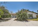 Traditional single-story home with covered porch and mature landscaping in the front yard at 7898 Wishing Well Rd, Las Vegas, NV 89123