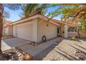 Charming home featuring a two-car garage, stucco exterior, tile roof, and desert landscaping at 8509 Lansdale Rd, Las Vegas, NV 89123
