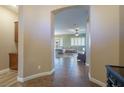 A spacious living room with tile flooring, an archway to a light-filled room, and neutral color palette at 9077 Creed Mountain Pl, Las Vegas, NV 89178