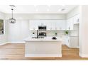 Modern kitchen with white cabinets, a waterfall island, and stainless steel appliances at 10017 Snow Crest Pl, Las Vegas, NV 89134