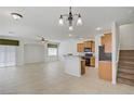 Bright open-concept living room with tile flooring, ceiling fan, and adjacent kitchen area at 10062 Aspen Rose St # 103, Las Vegas, NV 89183
