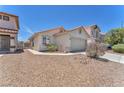 This home has a two-car garage and well-maintained desert landscaping at 1011 Dancing Vines Ave, Las Vegas, NV 89183
