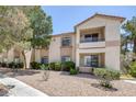 Well-maintained condo building with stucco exterior, mature landscaping, and gravel ground cover at 1830 N Buffalo Dr # 2024, Las Vegas, NV 89128