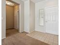 Bright foyer with neutral tones, tile and carpet flooring, and a white front door at 2026 Wildwood Lake St, Henderson, NV 89052