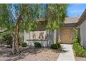 Inviting front entrance showcasing a tan door and neat landscaping with mature shade tree at 2026 Wildwood Lake St, Henderson, NV 89052
