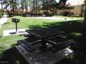 Community picnic area with a metal table and benches, and a barbecue grill in a grassy lawn at 2120 Ramrod Ave # 417, Henderson, NV 89014