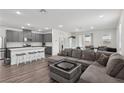 Open-concept living space featuring wood floors, recessed lighting, and a large sectional sofa at 3024 River Brook Ct, Las Vegas, NV 89139