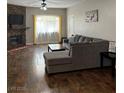 Living room features a cozy fireplace, wood flooring and a large sectional for relaxation and style at 3320 S Fort Apache Rd # 139, Las Vegas, NV 89117