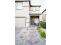 Inviting home exterior with a stone walkway, desert landscaping, covered porch and comfortable seating area at 4178 Eagle Island St, Las Vegas, NV 89130