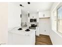 Bright kitchen features white cabinets, a breakfast bar, and modern stainless steel appliances at 5078 Mountain Vista St, Las Vegas, NV 89120