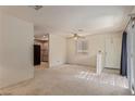 Spacious living room with neutral carpet, lots of natural light, and entry to the kitchen at 5249 Wave Dancer Ln, Las Vegas, NV 89118