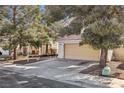 Charming beige two-story home featuring a two-car garage, driveway, and mature landscaping at 5636 Royal Castle Ln, Las Vegas, NV 89130