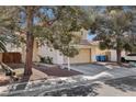 A charming beige two-story home with a two-car garage, desert landscaping, and plenty of curb appeal at 5636 Royal Castle Ln, Las Vegas, NV 89130