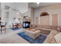 Open-concept living room with a unique fireplace, vaulted ceilings, and a comfortable sectional couch at 7120 Bear Paw Creek St # 101, Las Vegas, NV 89149