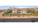 Aerial view of tan stucco home with balcony, surrounded by desert landscaping and a wrought iron fence at 743 N Orleans St, Henderson, NV 89015