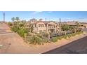 Aerial view of tan stucco house with balcony and desert landscaping surrounded by wrought iron fence at 743 N Orleans St, Henderson, NV 89015