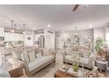 Open concept living room with neutral tones, tile flooring, and seamless flow to kitchen area at 7824 Warm Winds St, North Las Vegas, NV 89084