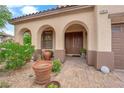 Welcoming entrance to a beautiful home with an arched portico and double doors at 9614 Stonily Ln, Las Vegas, NV 89178