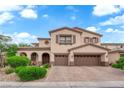 Charming two-story home featuring a two-car garage, arched entryway, and beautiful landscaping at 9614 Stonily Ln, Las Vegas, NV 89178
