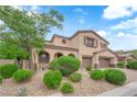Beautiful two-story home featuring a two-car garage, arched entryway, and mature landscaping at 9614 Stonily Ln, Las Vegas, NV 89178