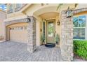 Charming front porch with stone columns and brick-paved driveway leading to the garage at 9729 Hawk Crest St, Las Vegas, NV 89141