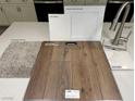 Selection of carpet, plank flooring, cabinetry, countertop, and fixtures for a cohesive design at 10283 Water Knot Ave, Las Vegas, NV 89166