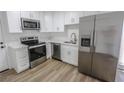 A modern kitchen featuring stainless steel appliances, marble countertops, and white cabinetry at 2711 Sesame Dr, Las Vegas, NV 89142