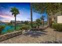 Back patio with beautiful water view with built in seating, lush green landscaping, and home exteriors at 2925 Coast Line Ct, Las Vegas, NV 89117