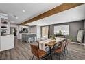 A dining area featuring a wood table, leather chairs, wooden ceiling beam, and modern open-concept design at 3013 Roseville Way, Las Vegas, NV 89102