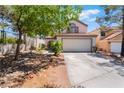 Charming home exterior features a two-car garage, desert landscaping, and mature trees in a residential neighborhood at 3200 Mariner Bay St, Las Vegas, NV 89117