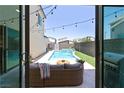Backyard oasis showcasing a sparkling pool, patio seating, string lights, and barbecue area at 3369 Ponicelli Ln, Henderson, NV 89044