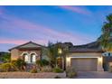 Charming single-story home featuring a well-manicured front yard and a two-car garage, nestled in a desert landscape at 34 Costa Tropical Dr, Henderson, NV 89011