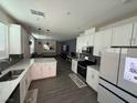 Open kitchen featuring white cabinets, modern appliances, and island seating at 3447 Sw Covilha Ln, Henderson, NV 89044