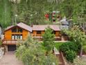 Charming wooded home featuring a large deck, brown metal roof, and an attached garage at 3935 White Fir Way, Mount Charleston, NV 89124