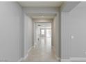 Bright hallway featuring neutral paint and tile flooring leading to an open living space with lots of natural light at 425 Canary Song Dr, Henderson, NV 89011