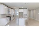 Modern kitchen featuring white cabinets, granite countertops, stainless steel appliances, and a center island with seating at 425 Canary Song Dr, Henderson, NV 89011