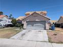 View of home featuring two-car garage, desert landscaping, and tile roof at 5004 Deep Forest Dr, Las Vegas, NV 89130