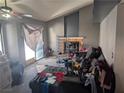Living room area with vaulted ceilings, fireplace, ceiling fan, and sliding door access at 5004 Deep Forest Dr, Las Vegas, NV 89130